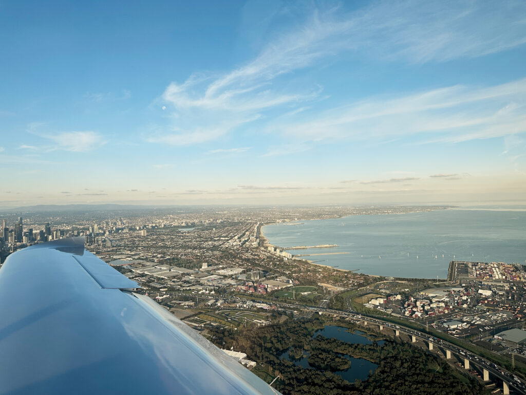 Aerial view of Melbourne coastline from cockpit during a flight test, illustrating the final stage of CASA pilot licence conversion in Australia.