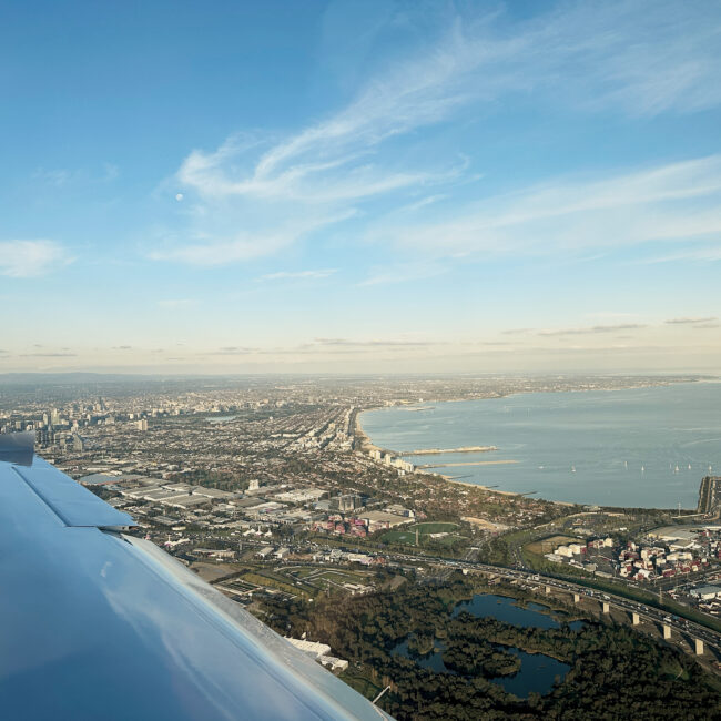 Aerial view of Melbourne coastline from cockpit during a flight test, illustrating the final stage of CASA pilot licence conversion in Australia.