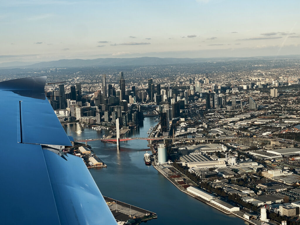 Aerial view of Melbourne city skyline from a training aircraft, highlighting the experience of becoming a flight instructor in Australian airspace.