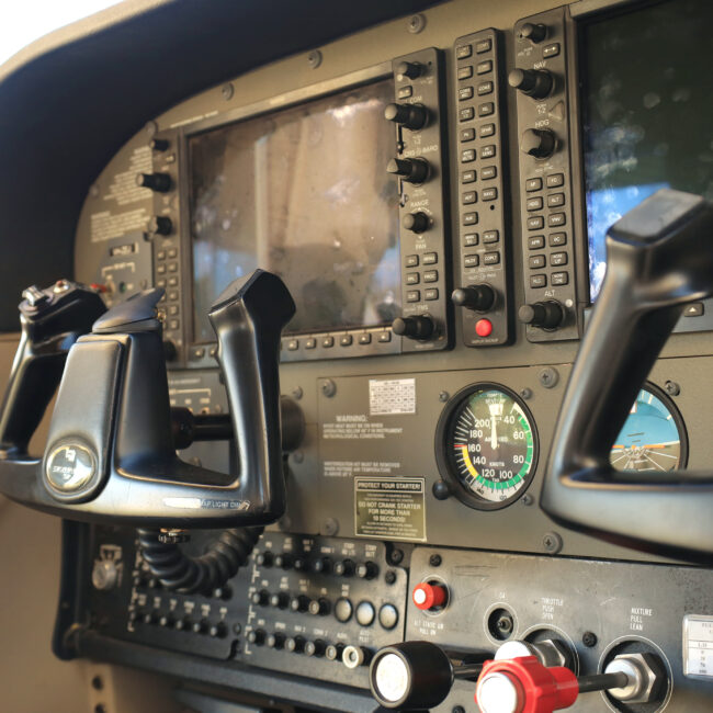 Close-up view of an aircraft cockpit showing dual controls and avionics—highlighting the advanced systems used in both private and commercial pilot training.