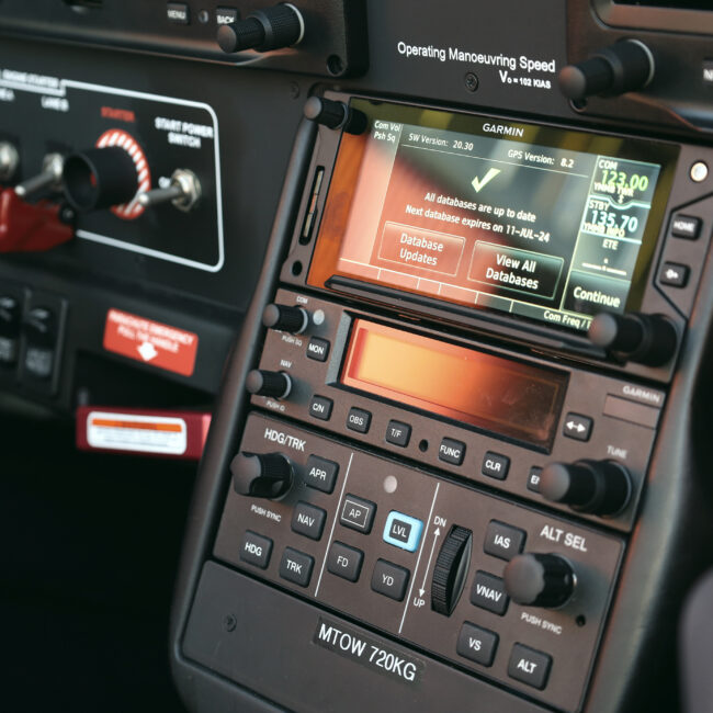 Close-up of a modern aircraft cockpit control panel showing navigation and communication systems during pre-flight setup.