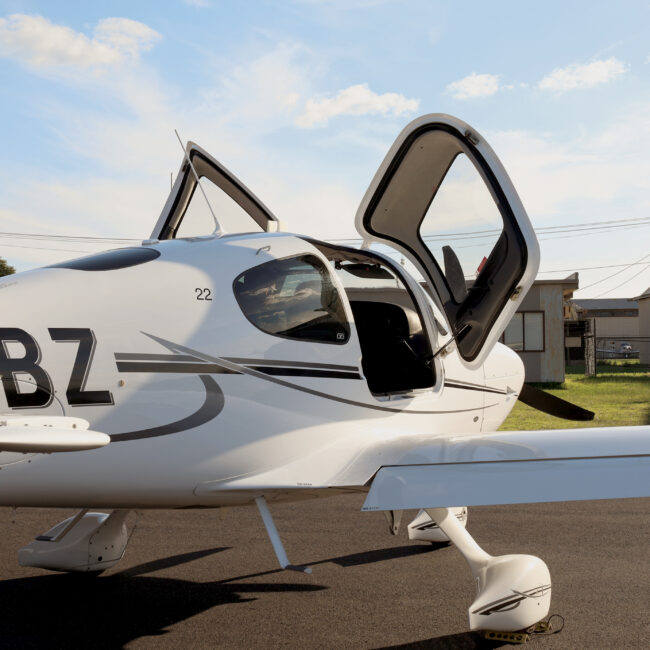 Modern light aircraft on the tarmac with doors open, used for Private Instrument Rating and Instrument Rating training at a general aviation airport.